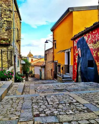an alley in a town with a mural on a building at B&B Rampante in Piana degli Albanesi