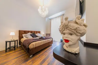 a bedroom with a bed and a statue on a table at Palazzo Ardizzone in Palermo
