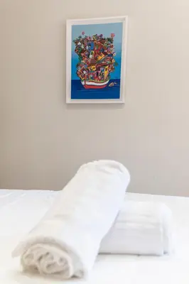 a towel laying on a bed with a picture on the wall at B&B Ruggero Settimo - Room & Suite in Palermo