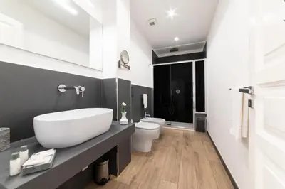 a bathroom with a white sink and a toilet at B&B Ruggero Settimo - Room & Suite in Palermo