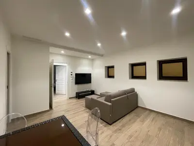 a living room with a couch and a flat screen tv at B&B Ruggero Settimo - Room & Suite in Palermo