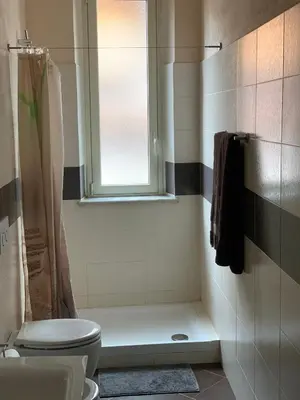 a bathroom with a shower and a toilet and a window at Casa Casteldaccia 2 in Casteldaccia