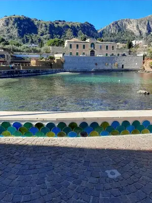 a body of water with a building in the background at Casa nel borgo marinaro di Santa Nicolicchia in Santa Flavia