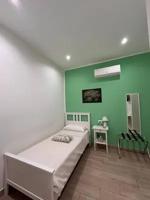 a bedroom with a bed and a green wall at A Casa di Josephine in Palermo