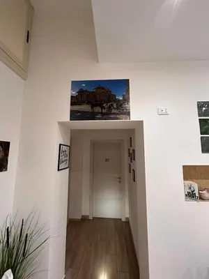 a hallway with a white wall with pictures on it at A Casa di Josephine in Palermo