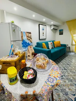 a living room with a blue couch and a table with food at Duba House Holiday Home in Palermo