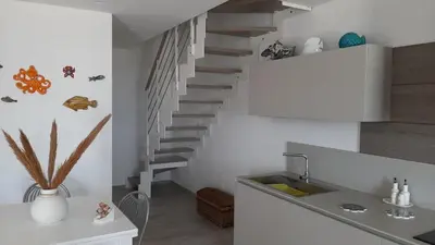 a kitchen with a spiral staircase and a sink at stella di ponente in Macari