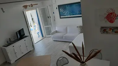 a living room with a white couch and a television at stella di ponente in Macari