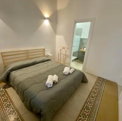 a bedroom with a bed with two towels on it at Piazza Florio Rooms in Palermo