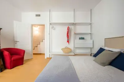 a bedroom with a bed and a red chair at Magione Apartment with Terrace by Wonderful Italy in Palermo