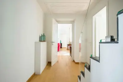 a room with a hallway with white walls and wooden floors at Magione Apartment with Terrace by Wonderful Italy in Palermo