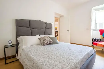 a bedroom with a large bed and a red chair at Magione Apartment with Terrace by Wonderful Italy in Palermo