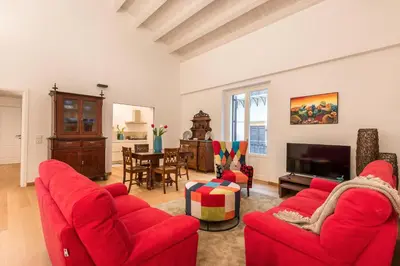 a living room with red couches and a tv at Magione Apartment with Terrace by Wonderful Italy in Palermo