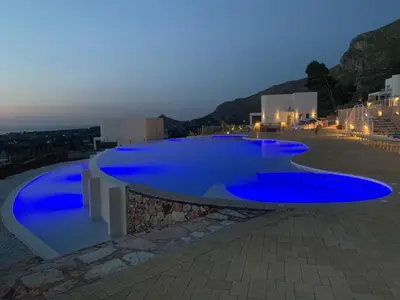 a large blue swimming pool on top of a building at Villa Mendez in Castellammare del Golfo