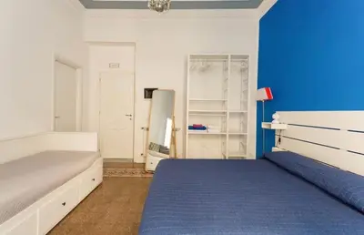a bedroom with a bed and a blue wall at Charmie flat in Palermo