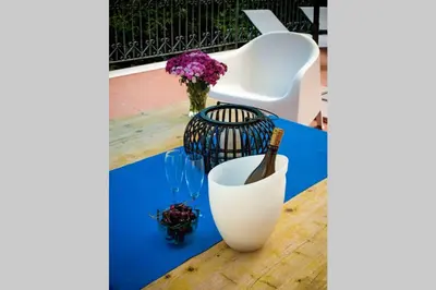 a table with a white vase and flowers on it at Villa la Rina in Palermo