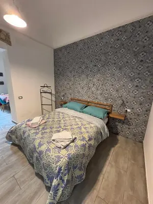 a bedroom with a bed with a patterned wall at Dost in Palermo