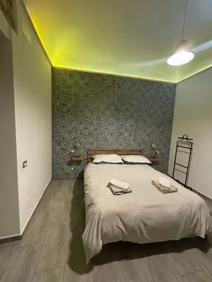a bedroom with a large bed with a green wall at Dost in Palermo