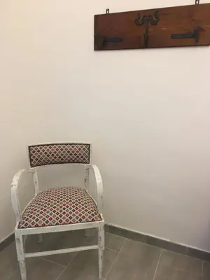 a chair in a room with a white wall at Dost in Palermo