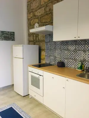 a kitchen with white cabinets and a white refrigerator at Dost in Palermo