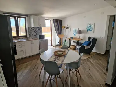 a kitchen and living room with a table and chairs at Kalimera in Capaci