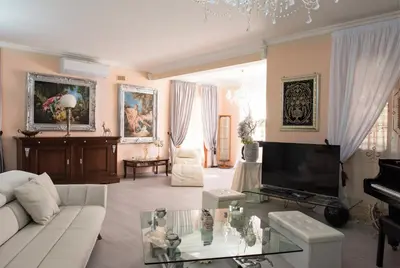 a living room with a white couch and a television at Villa Blondie con piscina a Castellammare del Golfo in Castellammare del Golfo