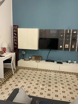 a living room with a tv on a blue wall at Funky flat in Palermo