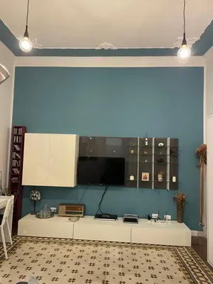 a kitchen with a blue wall and a white counter at Funky flat in Palermo