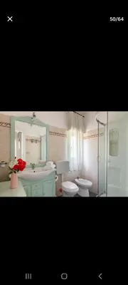 a bathroom with a sink and a toilet and a mirror at Villa Teresa in Trappeto