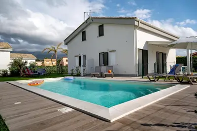a villa with a swimming pool in front of a house at Residence Salinelle Beach Villa Vulcano 4 in Lascari