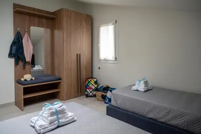 a bedroom with a bed and a chair and a window at Residence Salinelle Beach Villa Vulcano 4 in Lascari