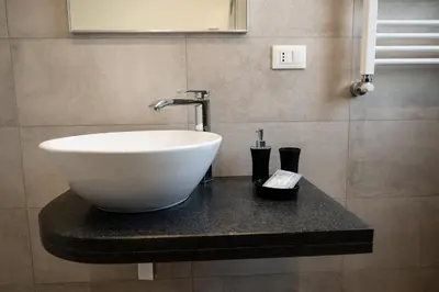a white bowl sink on a counter in a bathroom at Residence Salinelle Beach Villa Vulcano 4 in Lascari