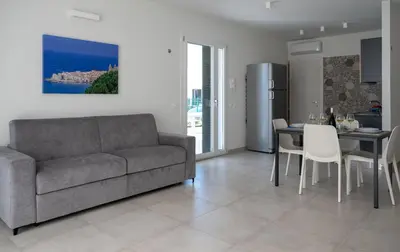 a living room with a couch and a table at Residence Salinelle Beach Villa Vulcano 4 in Lascari