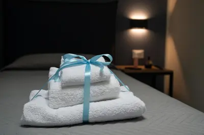 a stack of towels with a blue bow on a bed at Residence Salinelle Beach Villa Vulcano 4 in Lascari