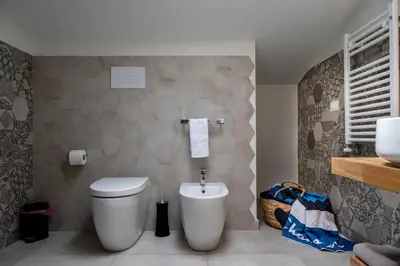 a bathroom with a toilet and a sink at Residence Salinelle Beach Villa Vulcano 4 in Lascari