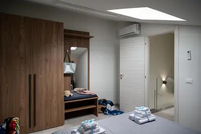 a bedroom with a bed and a wooden cabinet at Residence Salinelle Beach Villa Vulcano 4 in Lascari