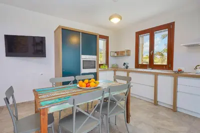 a kitchen and dining room with a table and chairs at Villa della Pigna in Scopello