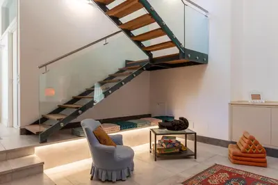 a living room with a staircase and a chair at Valverde Art Space Loft by DomuSicily in Palermo