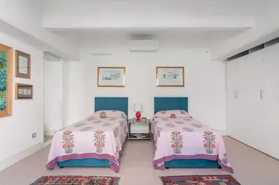 two beds in a room with white walls at Valverde Art Space Loft by DomuSicily in Palermo