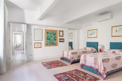 two beds in a room with white walls at Valverde Art Space Loft by DomuSicily in Palermo