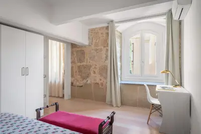 a bedroom with a bed and a desk and a window at Valverde Art Space Loft by DomuSicily in Palermo