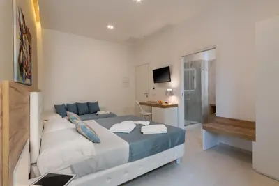 a bedroom with a bed with blue and white sheets at Artemide Hotel in San Vito lo Capo