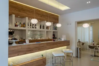 a bar with two stools and a counter with bottles at Artemide Hotel in San Vito lo Capo