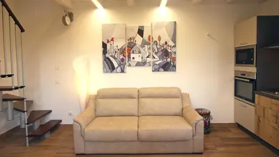 a living room with a couch and a painting on the wall at casa tre noci in Lascari
