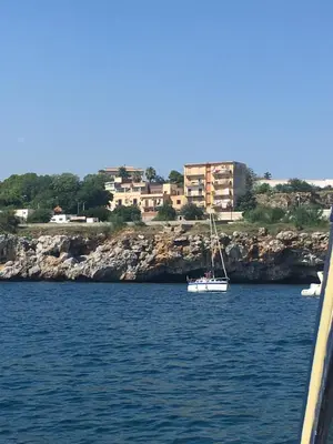 a small boat in the water near a city at Casa Igiea in Palermo