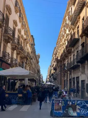a group of people walking down a street with buildings at Casa Igiea in Palermo