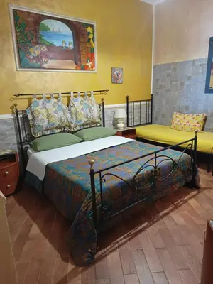 a bedroom with a large bed and a couch at Casa Igiea in Palermo