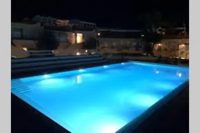 a large swimming pool lit up at night at Guisomar in Palermo