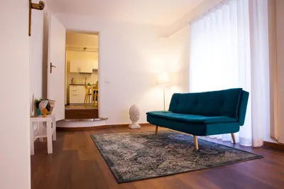 a living room with a blue couch and a rug at Casa MaMo 36 in Palermo