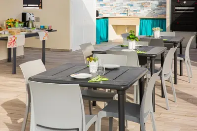 a dining room with black tables and white chairs at L' Arcobaleno B&B in Castelluzzo